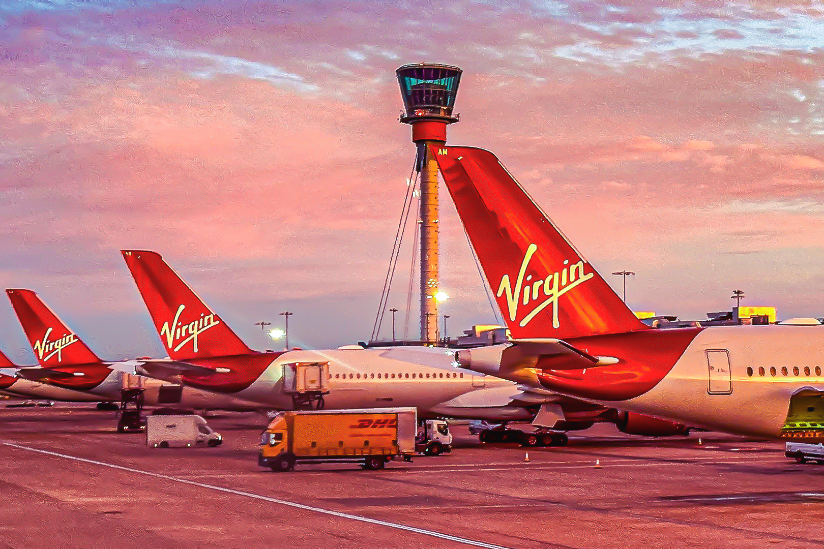 Tail fins of Virgin Atlantic Airways planes at London Heathrow Airport at dawn.