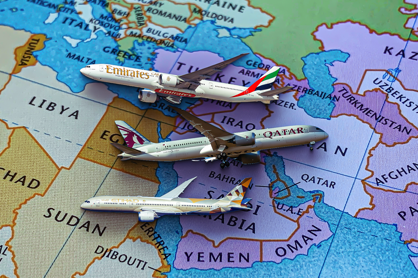 Emirates, Qatar, and Etihad jets flying over a map