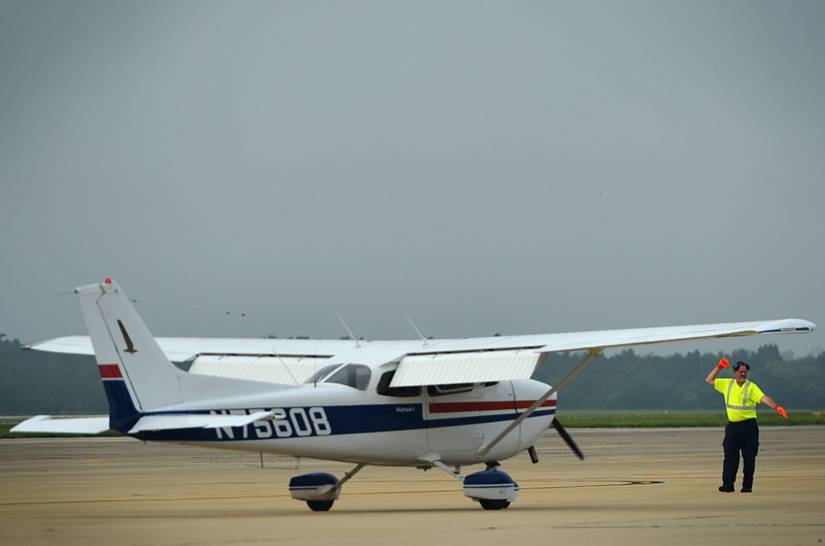 Tim Darrah, 20th Equipment Maintenance Squadron aircraft servicer, marshals a civilian Cessna 172, during a General Aviation Fly-in event