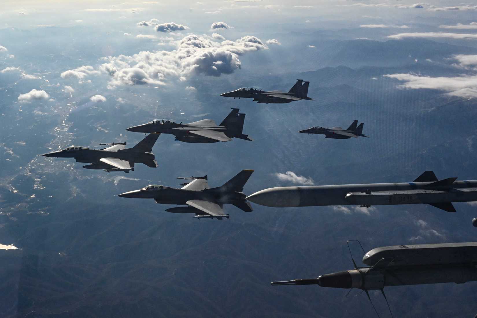Three Republic of Korea Air Force F-15K Slam Eagle aircraft, and two U.S. Air Force F-16 Fighting Falcon aircraft fly in formation