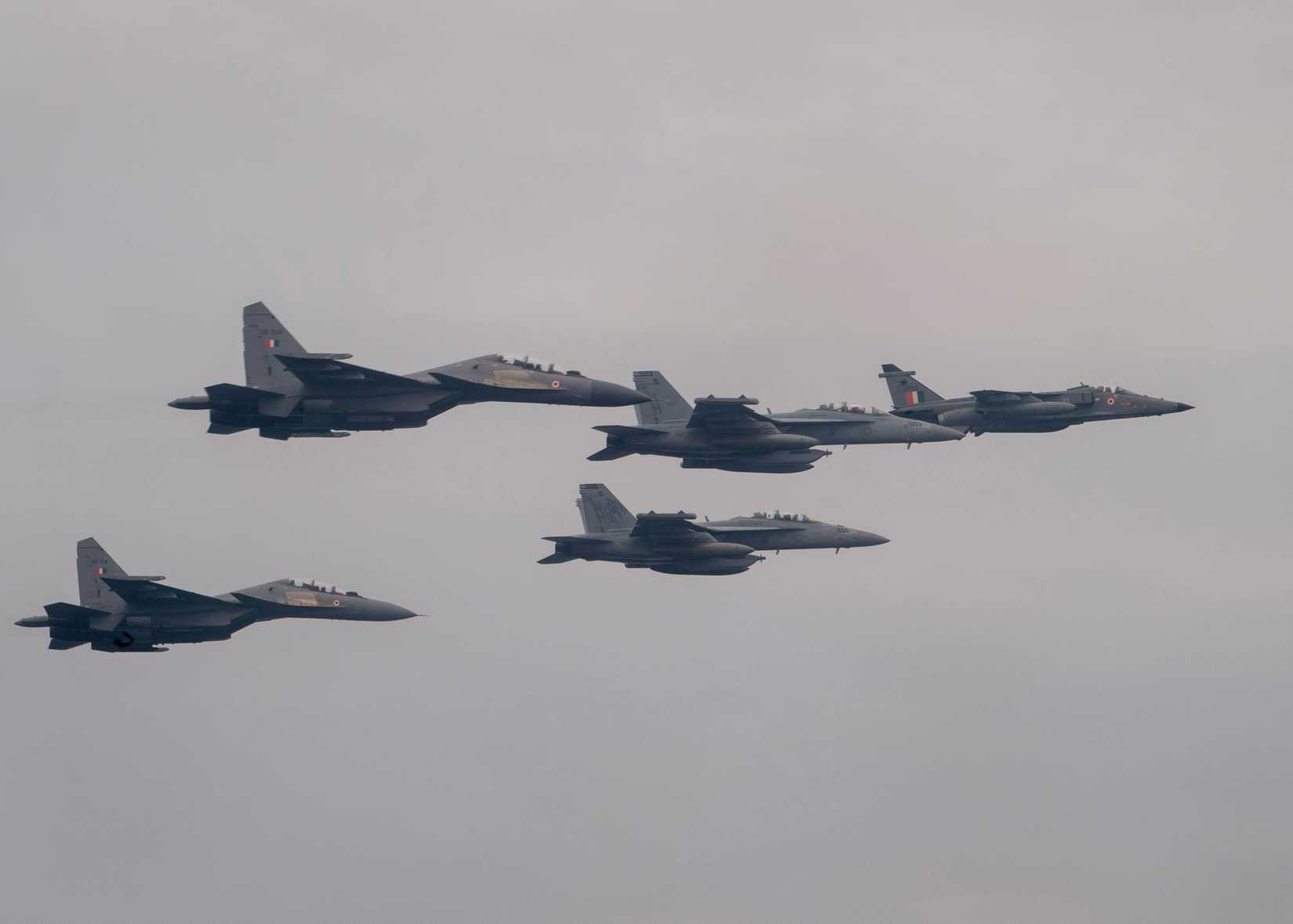 Two EA-18G Growlers, center, fly in formation with an Indian Air Force Jaguar, right, and two SU-30MKIs