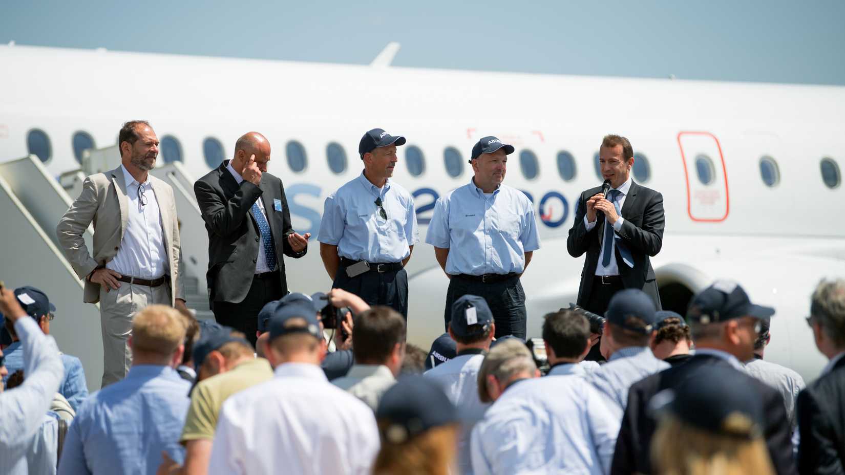 Airbus executives in front of an Airbus A220-300