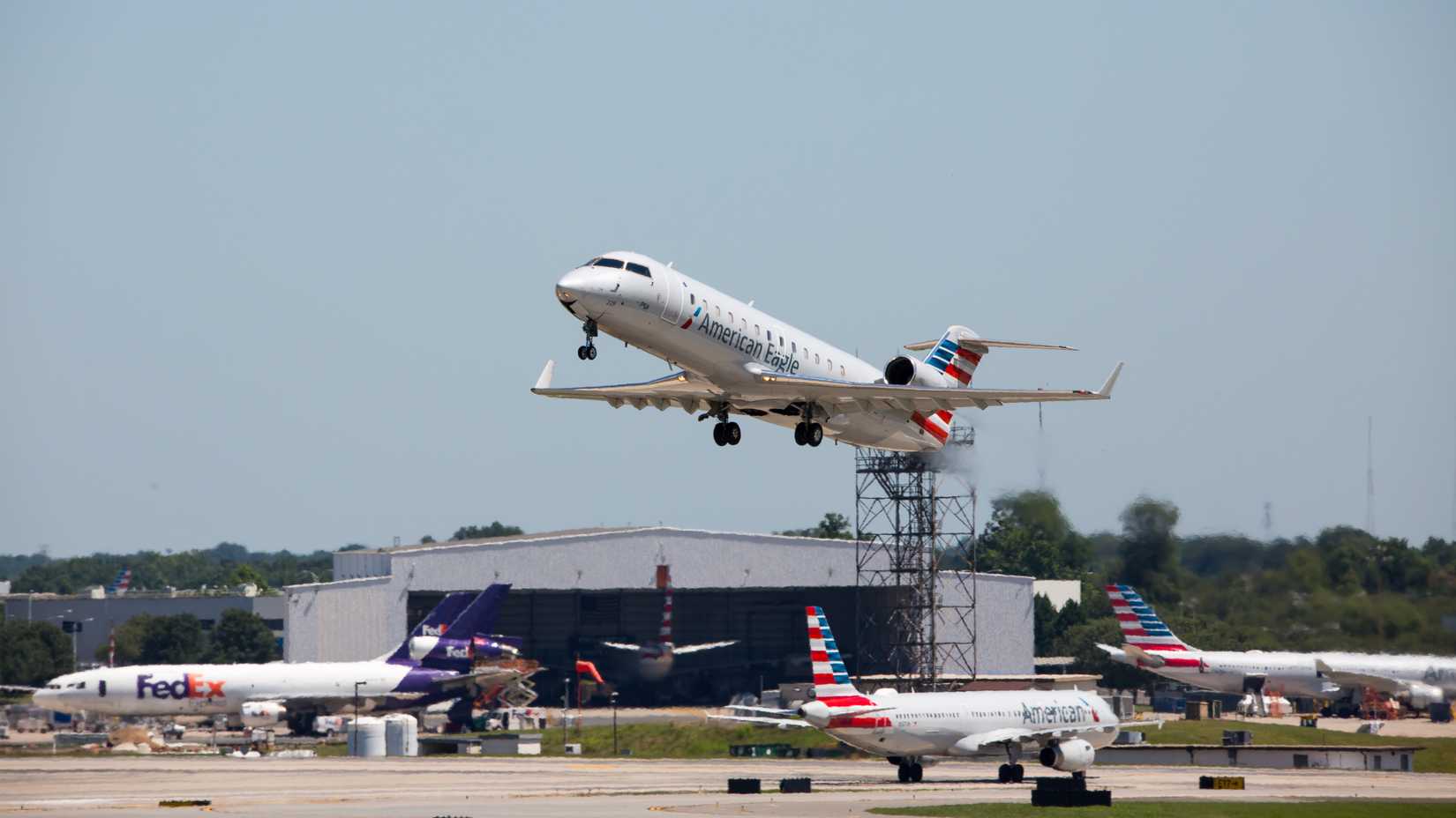 An American Eagle commercial jet takes off from a busy Charlotte-Douglas International Airport.