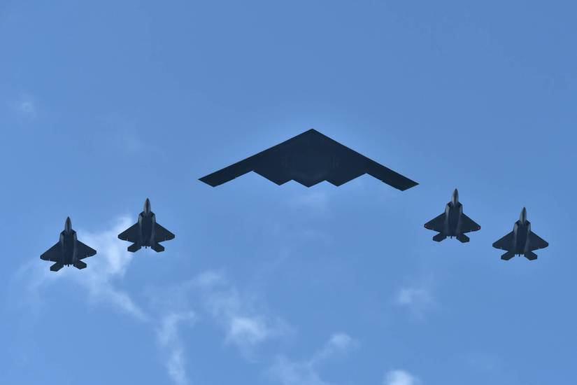 B-2 Spirit Stealth Bomber from Northrop Grumman flying with four F-22 Raptors from Lockheed Martin