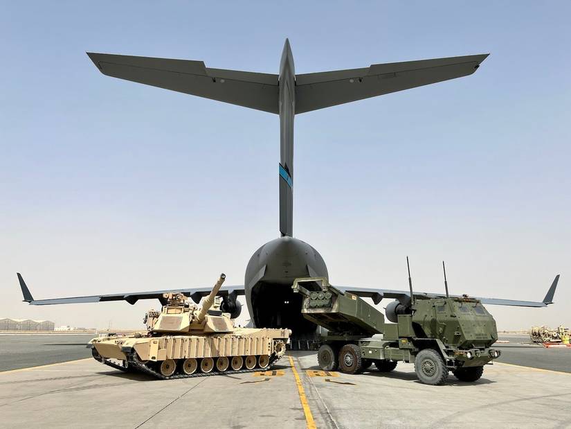 An M1 Abrams and a High Mobility Artillery Rocket System Ready themselves in front of a Boeing C-17.