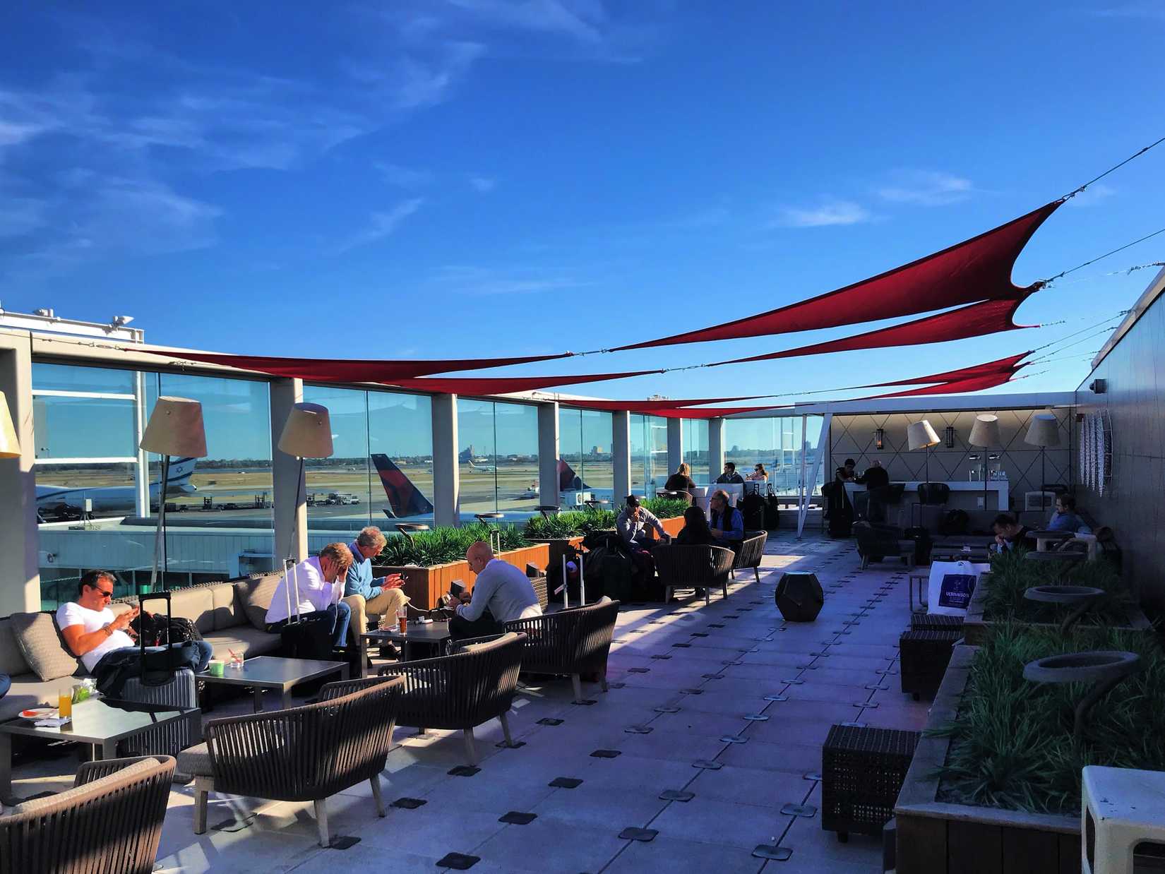 Business travelers look for relaxation on rooftop terrace of Delta's JFK Skyclub.