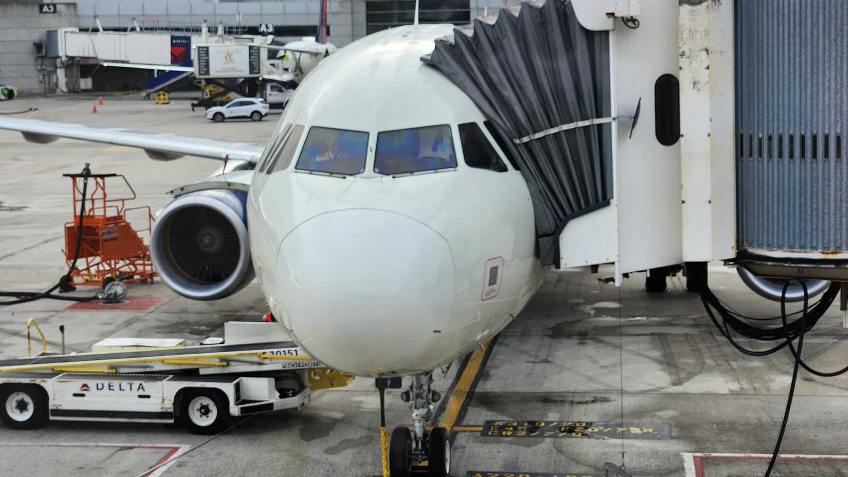 Delta Airlines airplane with pilots in the cockpit, jet bridge, Logan International Airport