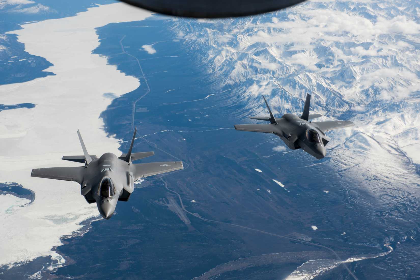Two F-35A Lightning II aircraft fly over the Alaska Canada Highway.