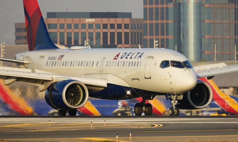 A Delta Airbus A220-100 decelerates on the runway after touching down in Orange County