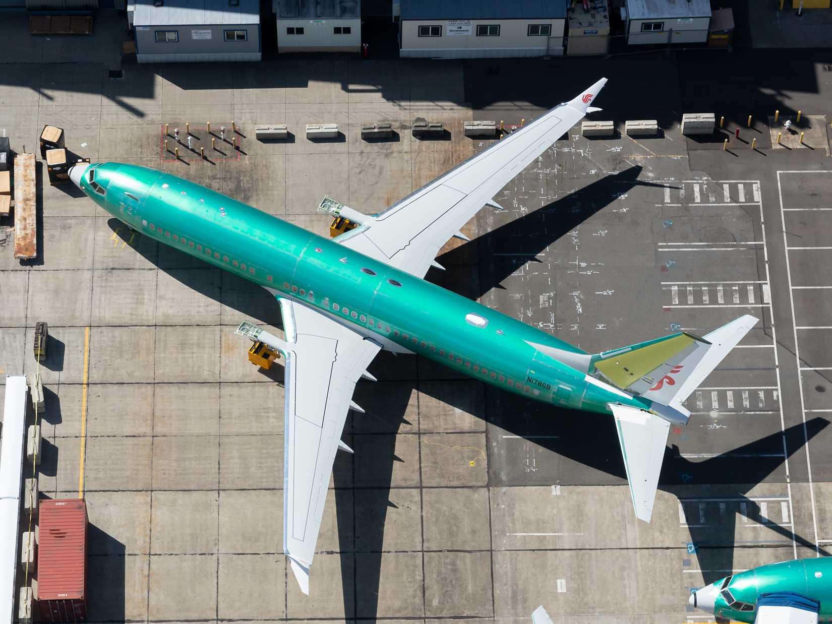 Boeing 737 MAX wearing protective green coat close to Boeing Factory at Renton Field. Aircraft tail showing Air Chine paint scheme.