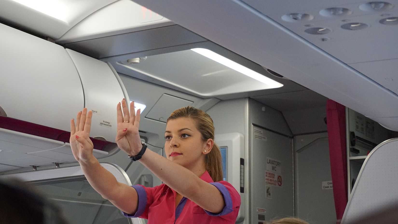 Flight attendant performs pre-flight safety demonstration