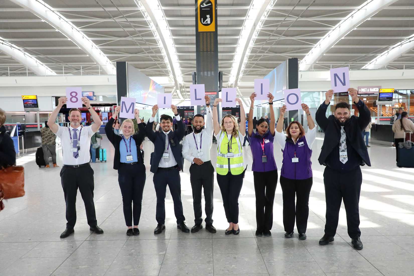 London Heathrow Airport Staff Pose With 8 Million Sign