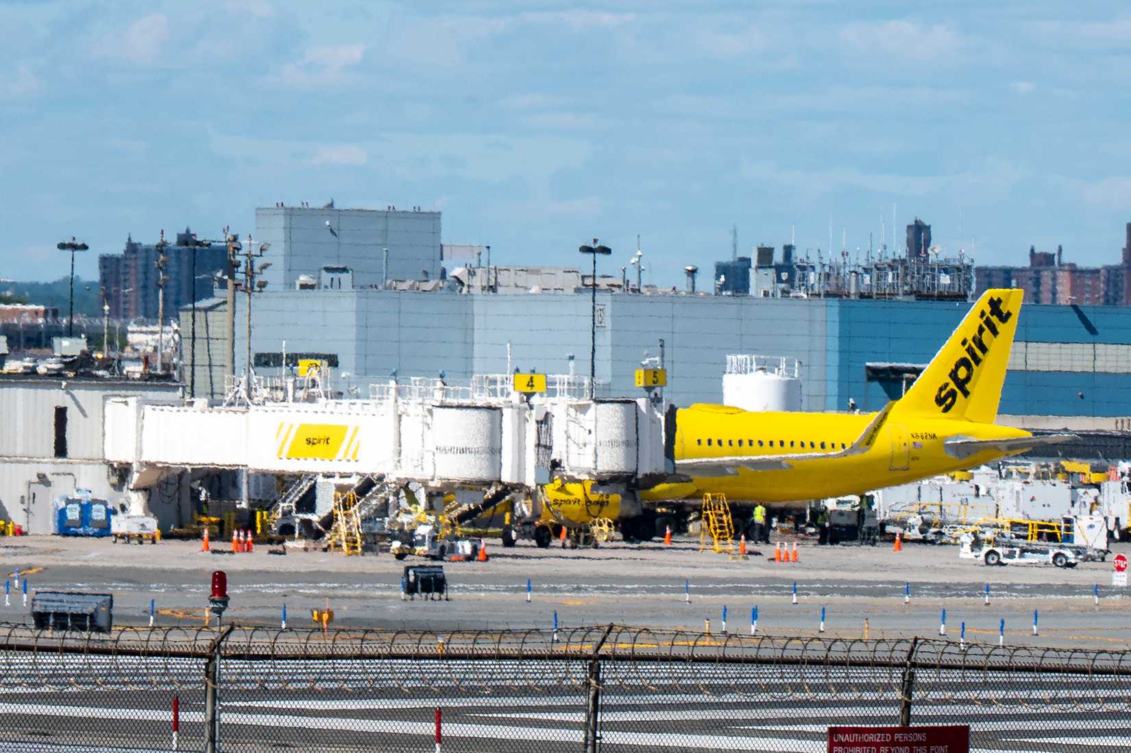 A Spirit Airlines Airbus A321-231 tail number N662NK airplane at a gate in LaGuardia Airport.