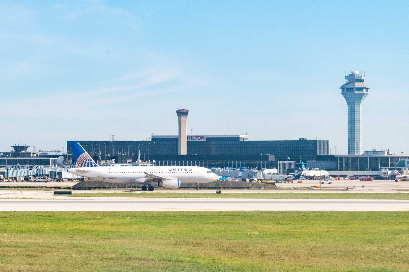 A United Airlines Airbus taxis in front of the Air Traffic Control tower and Airport Hilton hotel at ORD in Chicago