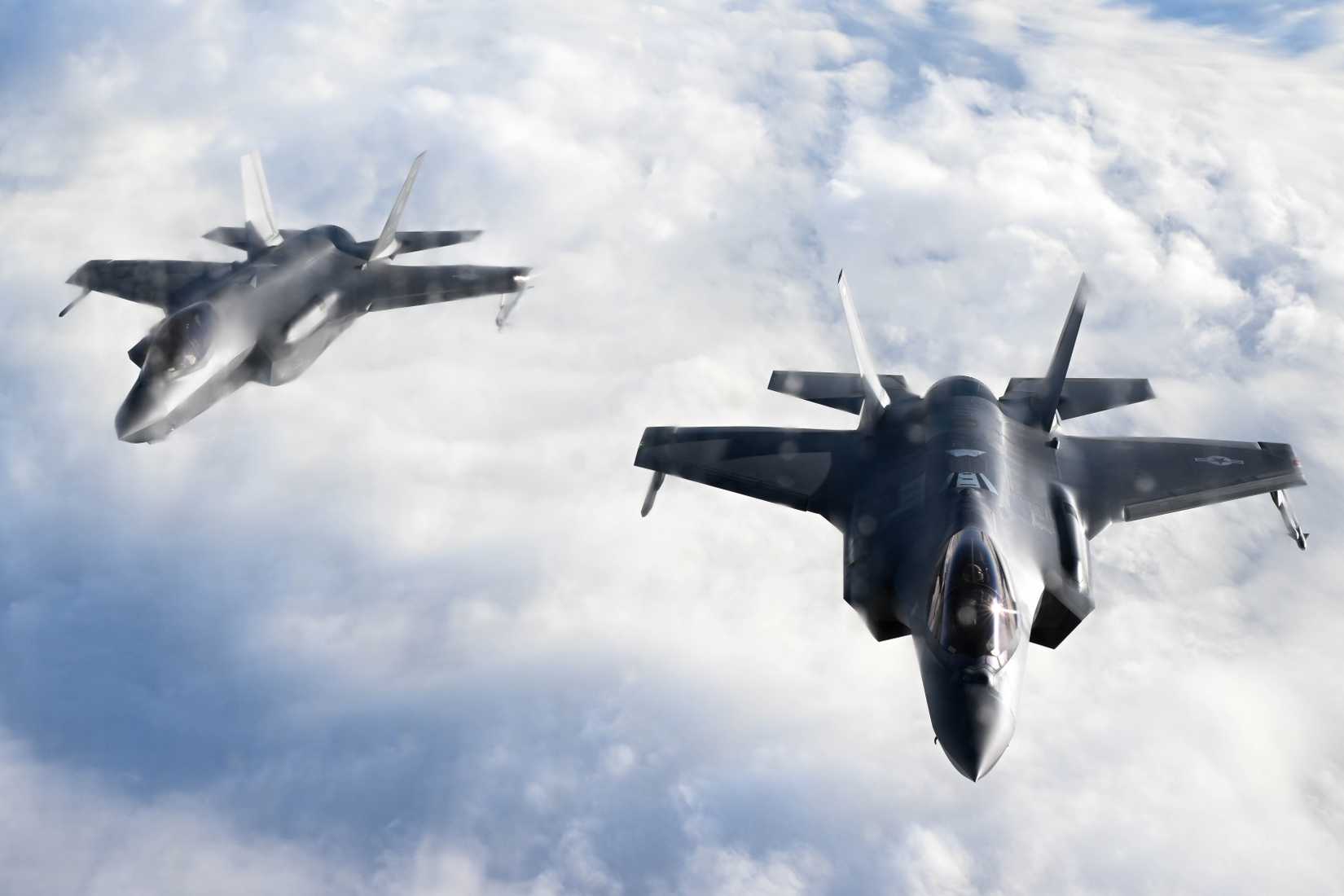 Air Force F-35 Lightning II assigned to the 354th Fighter Wing fly in formation behind a KC-135 Stratotanker.