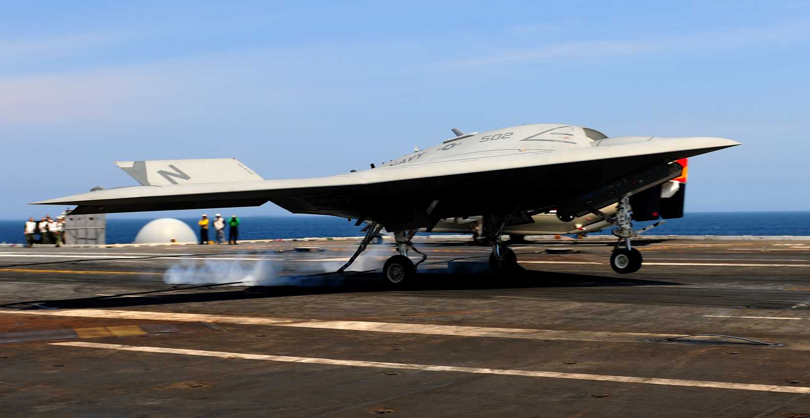 An X-47B Unmanned Combat Air System demonstrator completes an arrested landing on the flight deck of the aircraft carrier USS George H.W. Bush (CVN 77).