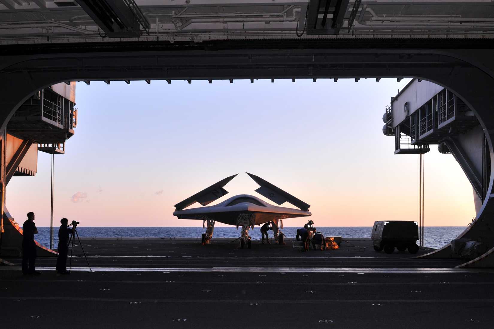 An X-47B Unmanned Combat Air System demonstrator is loaded on an aircraft elevator aboard the aircraft carrier USS George H.W. Bush (CVN 77).