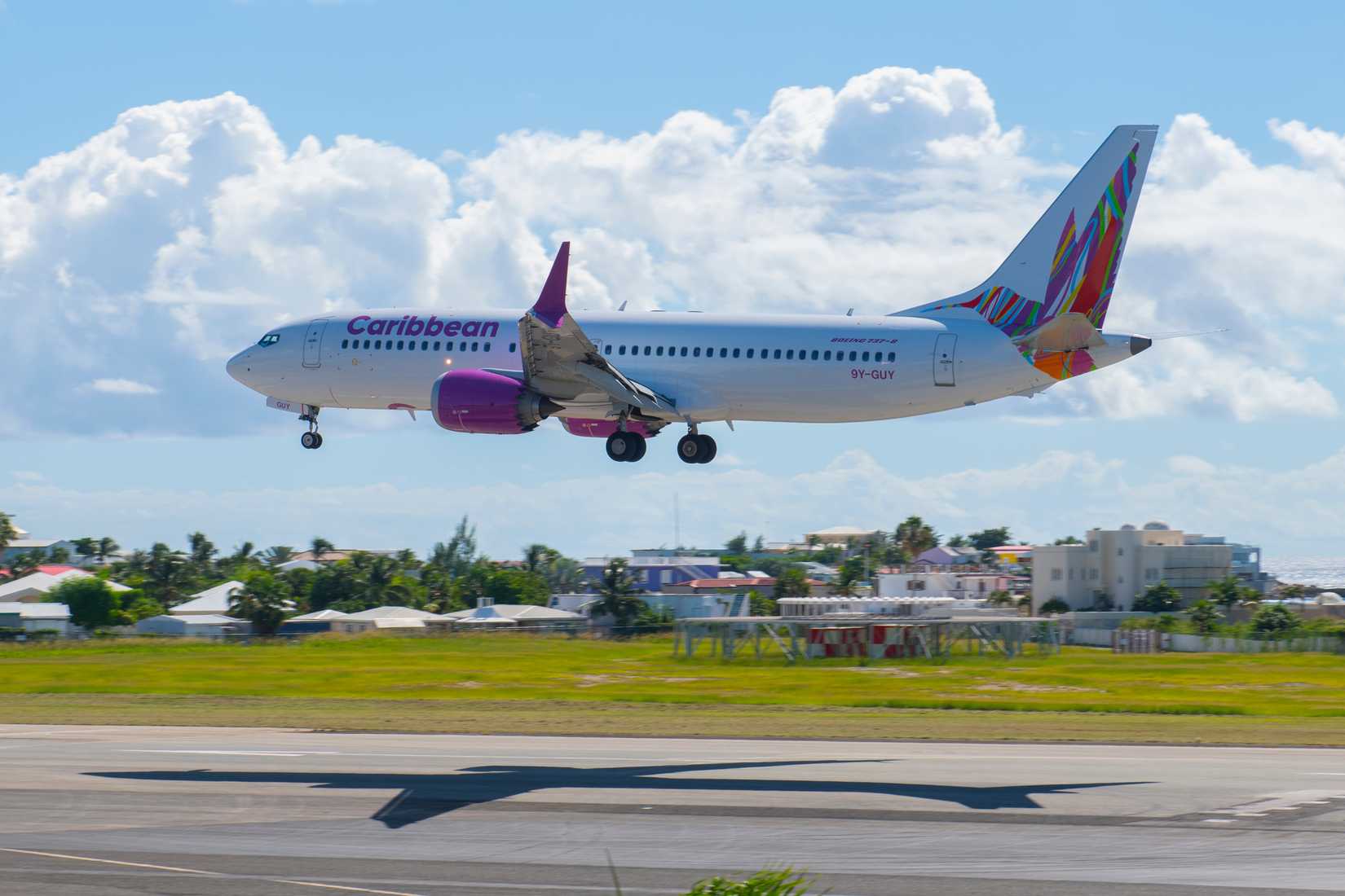 Caribbean Airlines Boeing 737 Max 8 9Y-GUY flying over Maho Beach before landing on Princess Juliana International Airport SXM on Sint Maarten, Dutch Caribbean.
