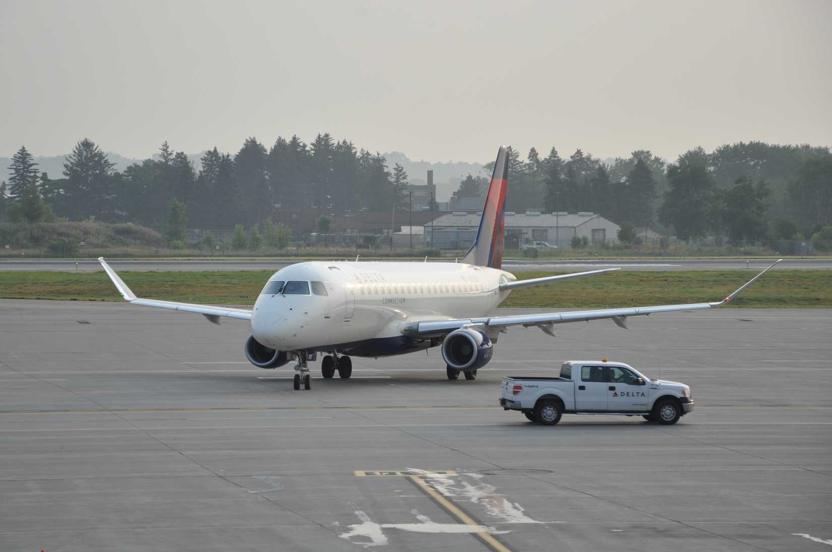 Delta Airlines' service crew car in front of a plane at the runway of Minneapolis - St. Paul International Airport.