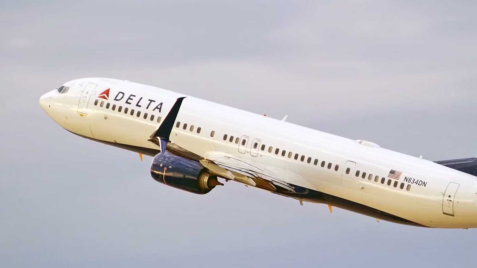 A Delta Air Lines Boeing 737-900ER flying in the sky.
