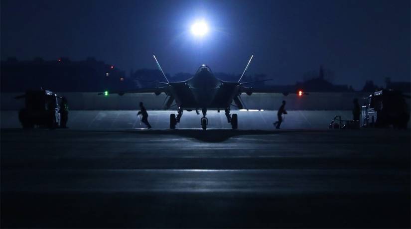 Ground crew assigned to an aviation brigade of the PLA Air Force perform inspections on a J-20 stealth fighter jet at night prior to a flight.