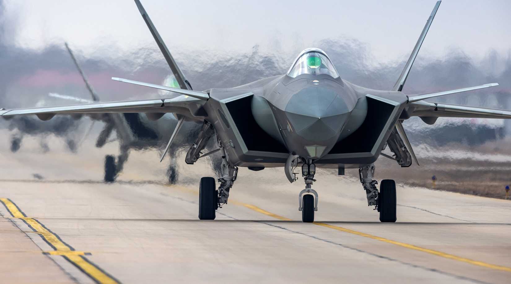 J-20 fighter jets attached to an aviation brigade under the PLA Air Force taxi in close formation.