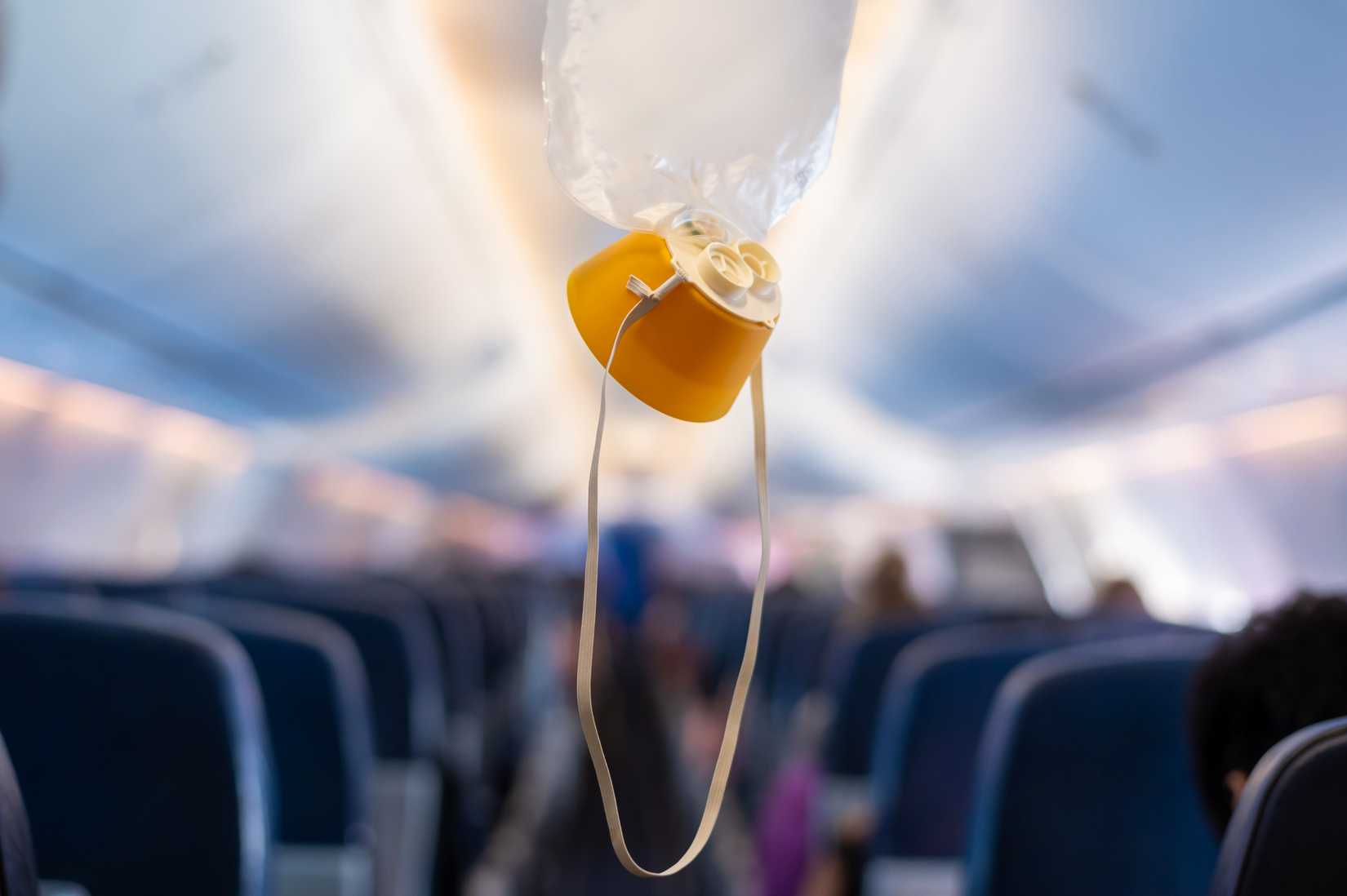 oxygen mask drop from the ceiling compartment on airplane.