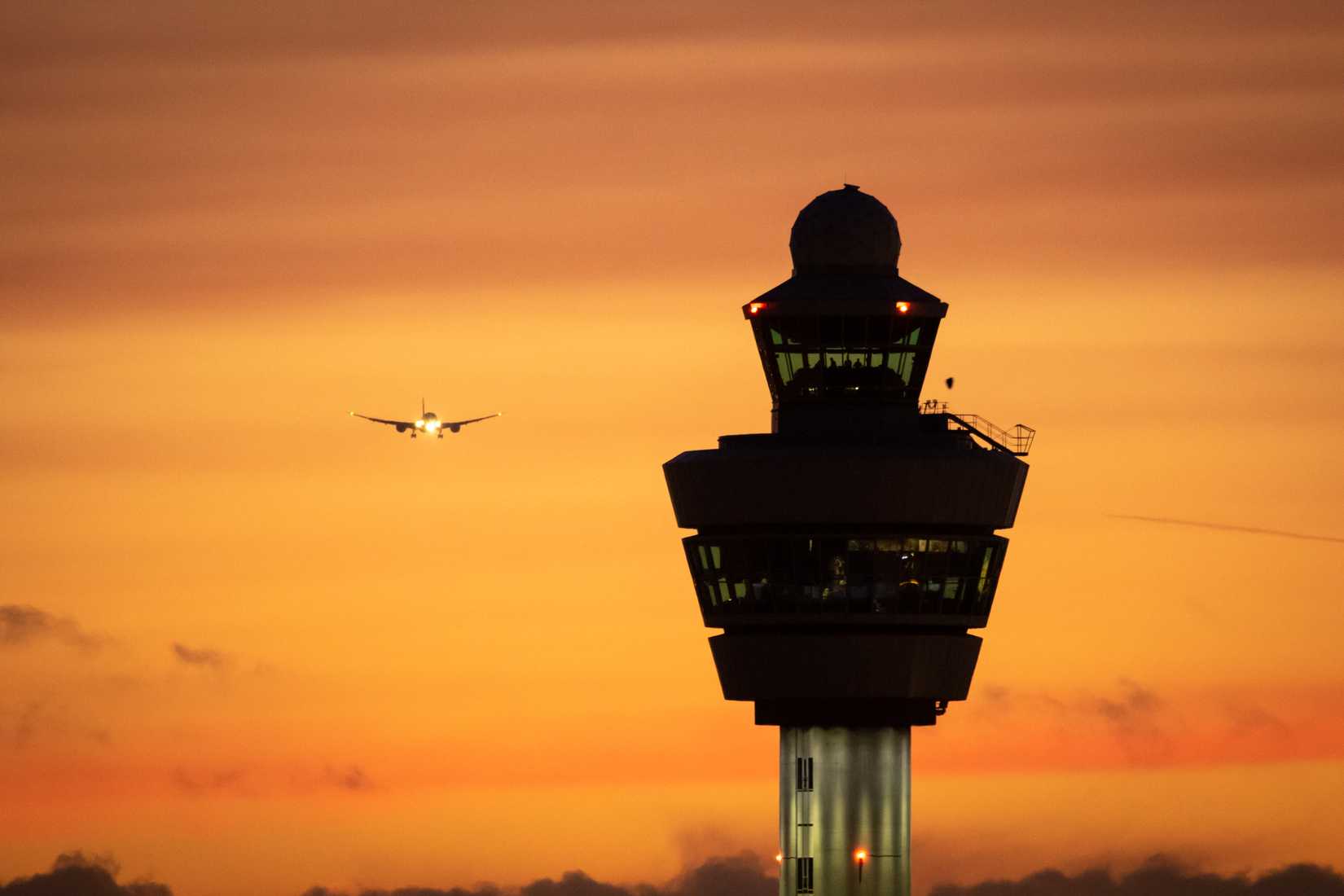 ATC tower and an airplane at sunset