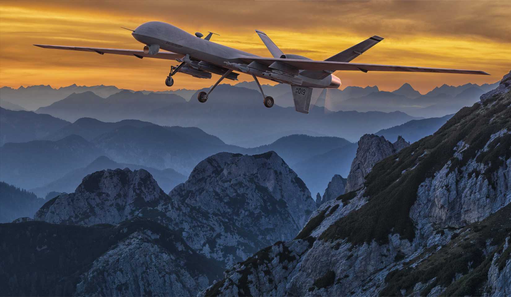 General Atomics MQ-9 Reaper drone flying over the mountains at sunset