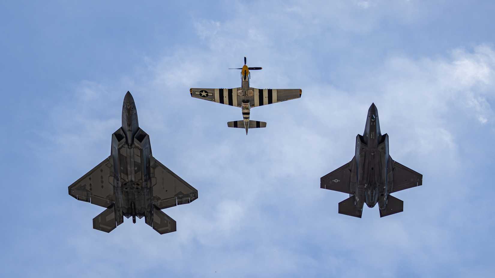 F-22 Raptor, P-51 Mustang and F-35 Lightning II fly by at an air show 
