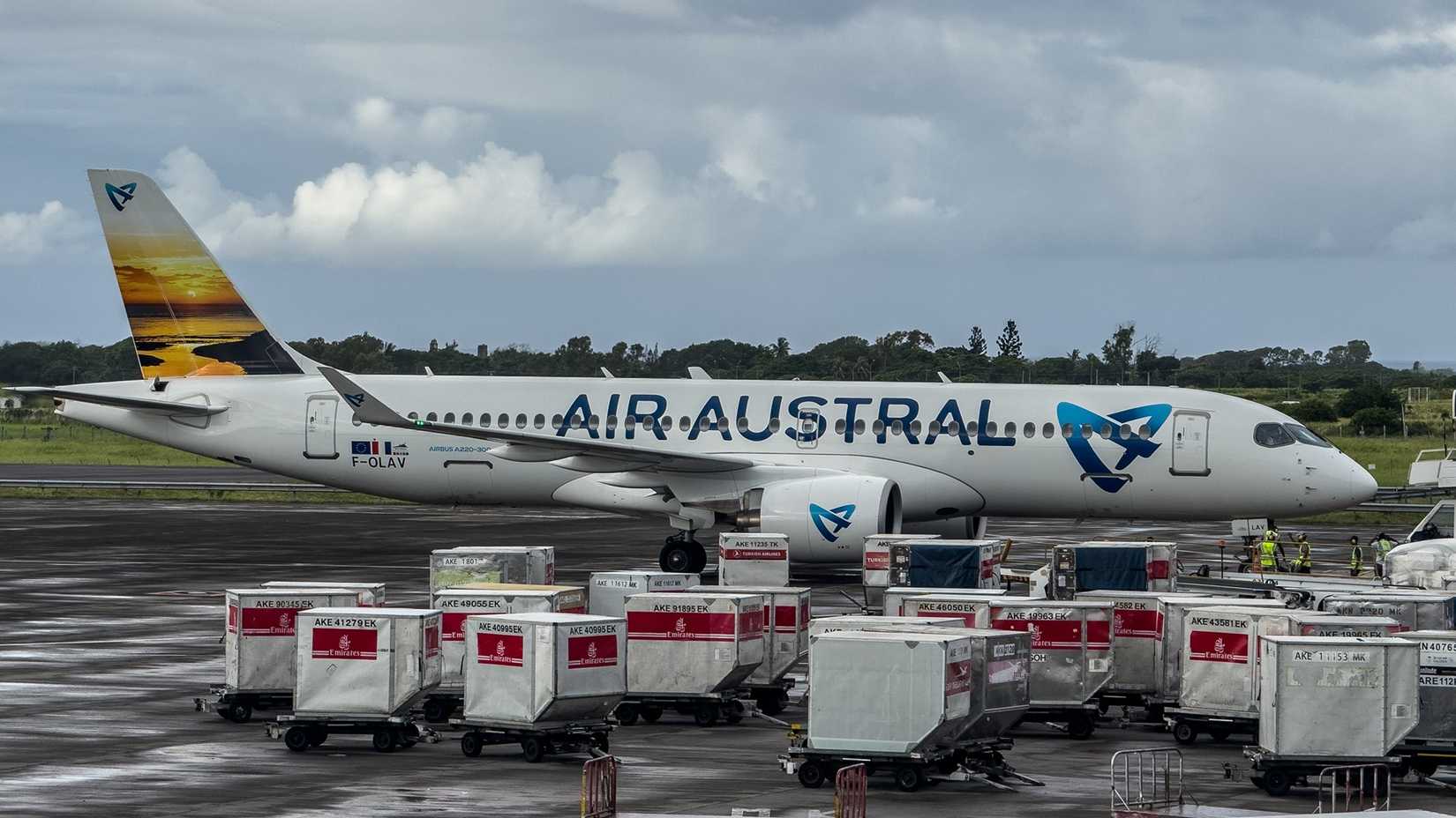 An Air Austral Airbus A220-300 parked at a gate area