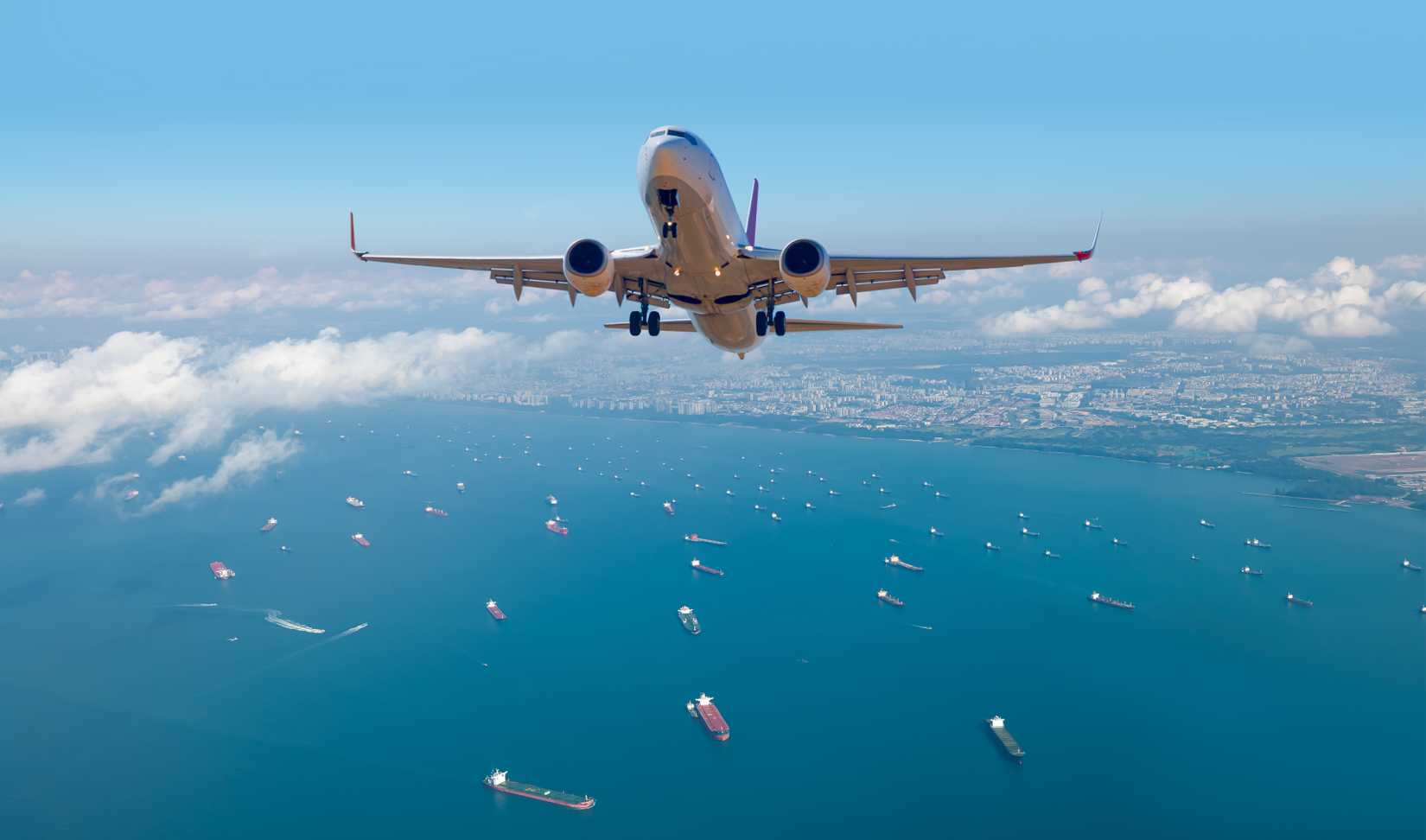 Passenger airplane is flying over mountains and sea 