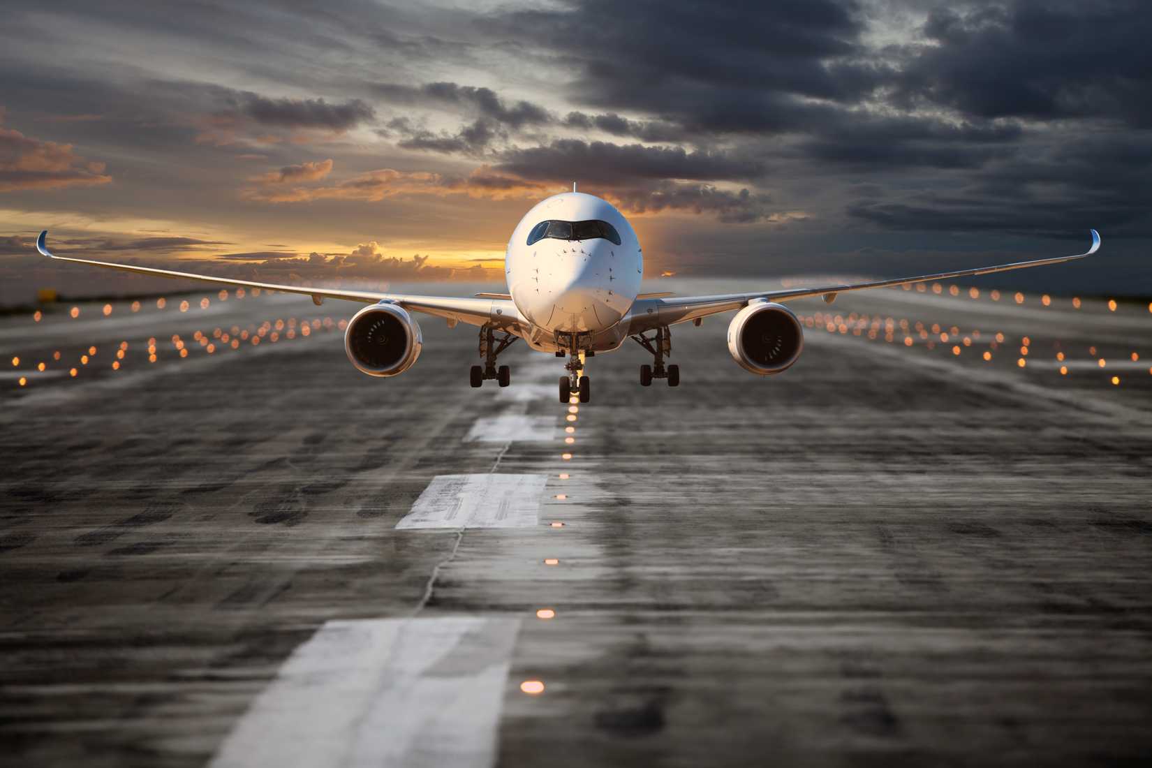 Passenger aircraft on the airport runway. Plane takes off at the sunset time. Airplane front view