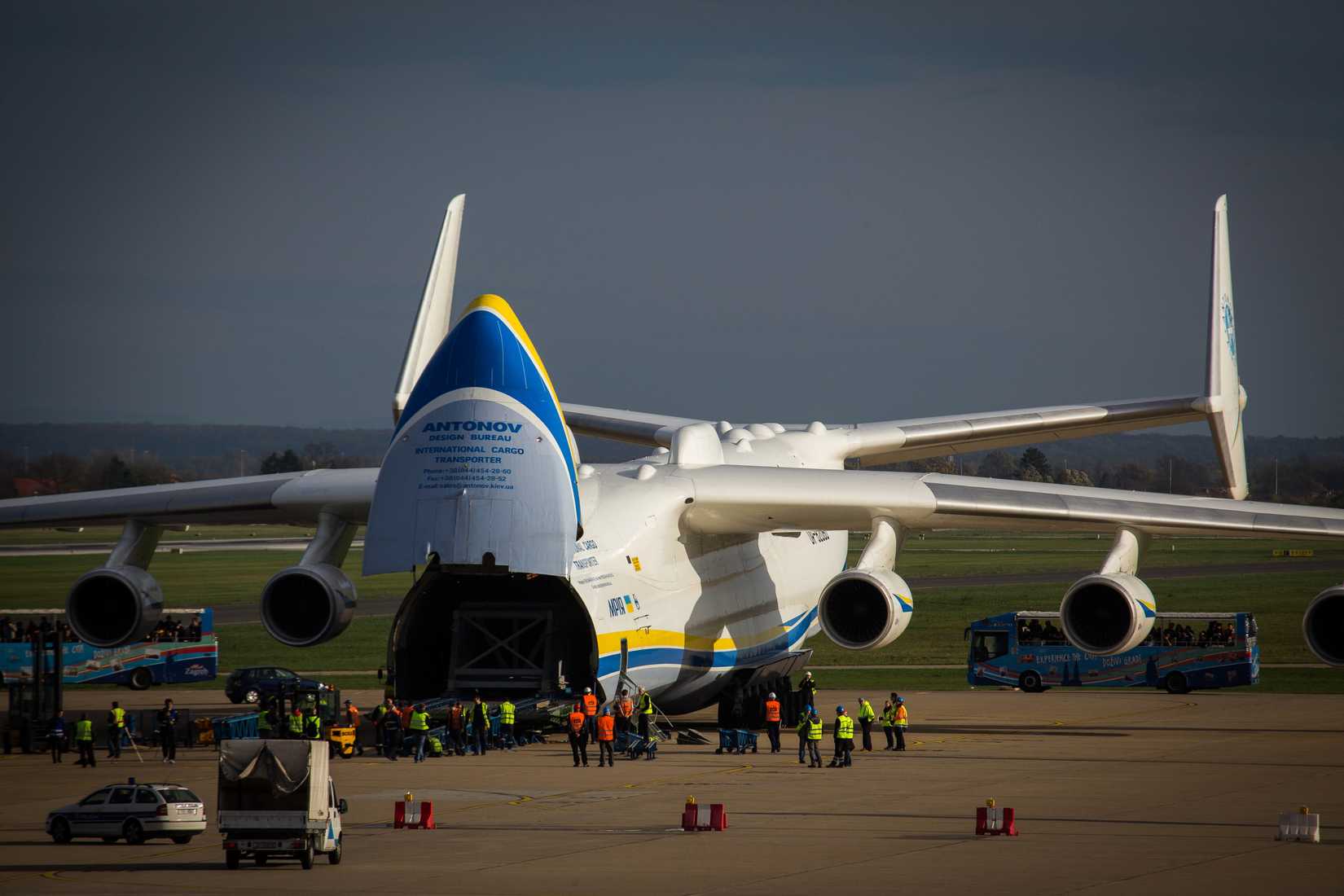 The Antonov An-225 parked at Pleso Airport with its nose open, ready to unload cargo with ground crew standing by.