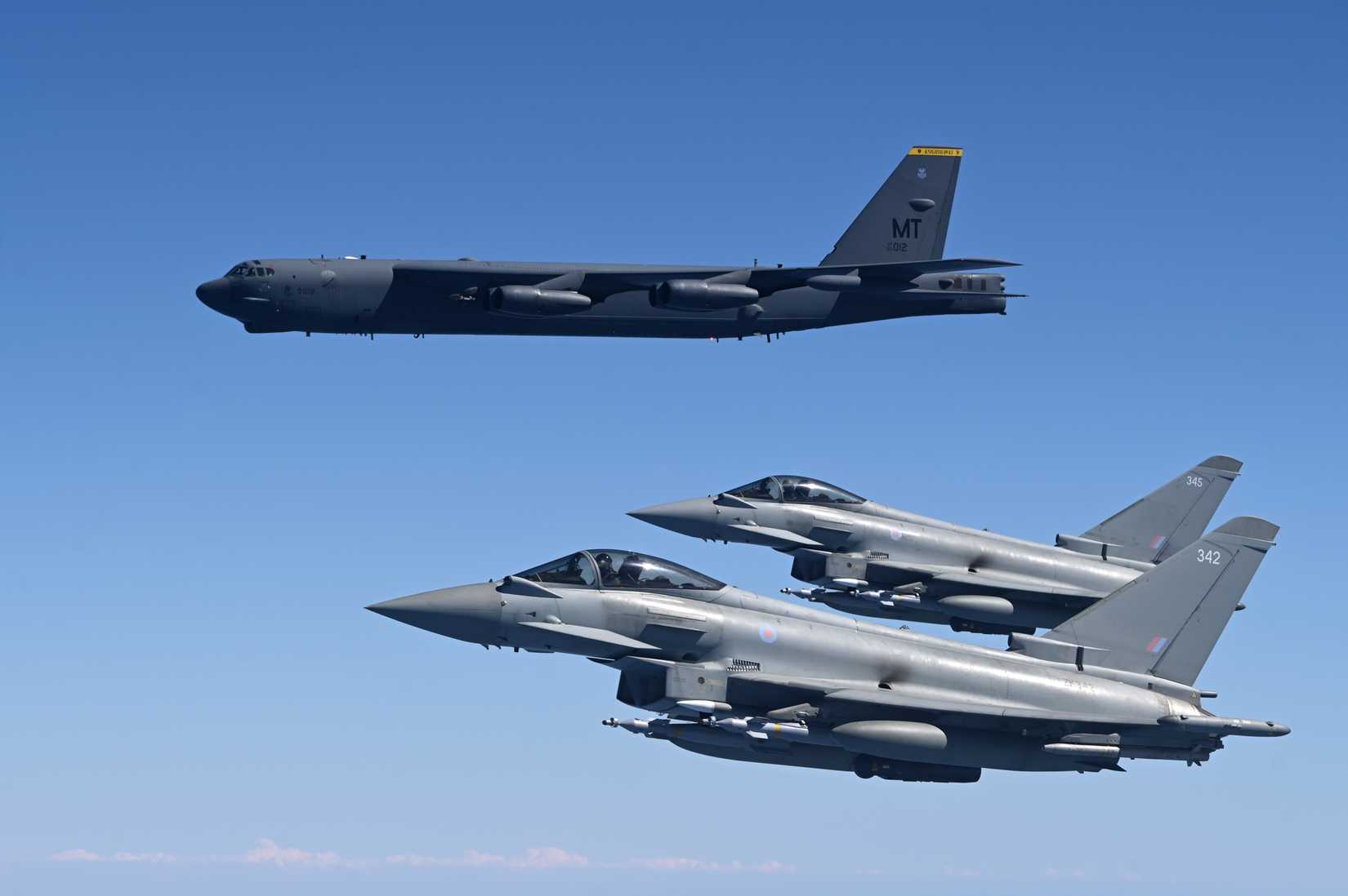 Two Royal Air Force Eurofighter Typhoons fly in formation with a U.S. Air Force B-52H Stratofortress.