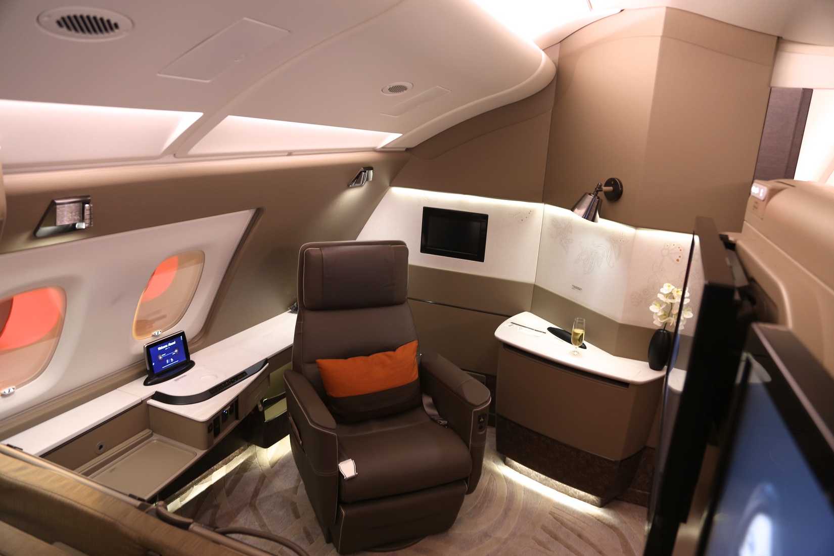 First Class Singapore Airlines Suite with windows, chair and inflight entertainment