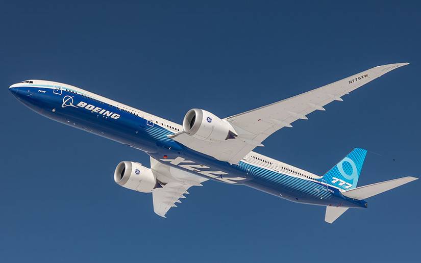 Boeing 777X flying in blue skies
