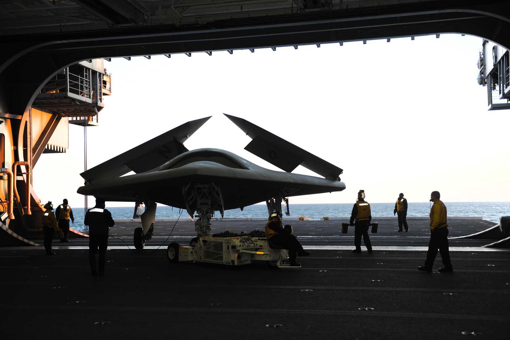 An X-47B Unmanned Combat Air System demonstrator is loaded onto an aircraft elevator aboard the aircraft carrier USS George H.W. Bush (CVN 77).