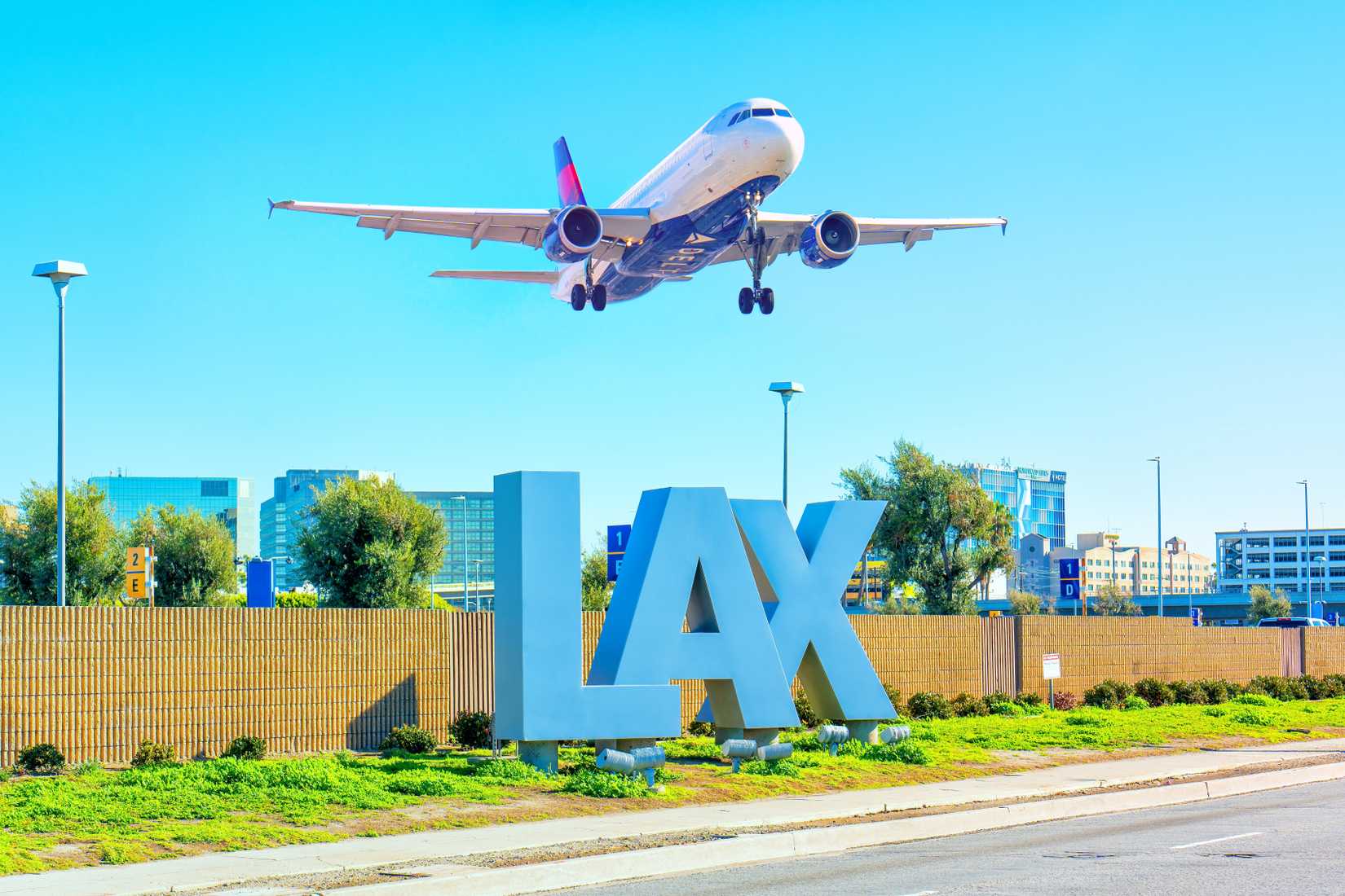 Delta Airlines plane takes off over the iconic LAX sign at Los Angeles International Airport.