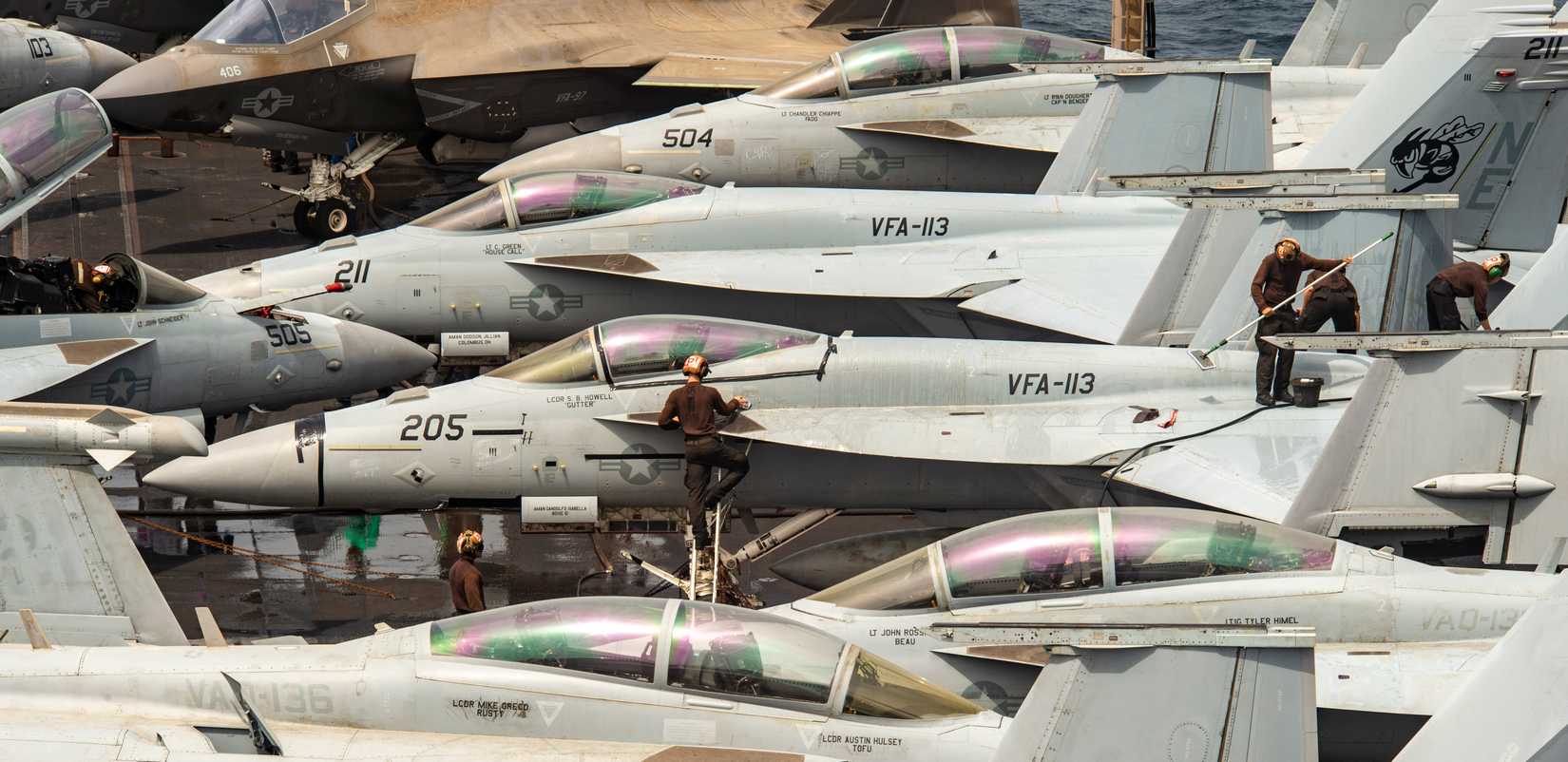 Sailors clean an FA-18F Super Hornet, on the flight deck of the Nimitz-class aircraft carrier USS Carl Vinson (CVN 70).