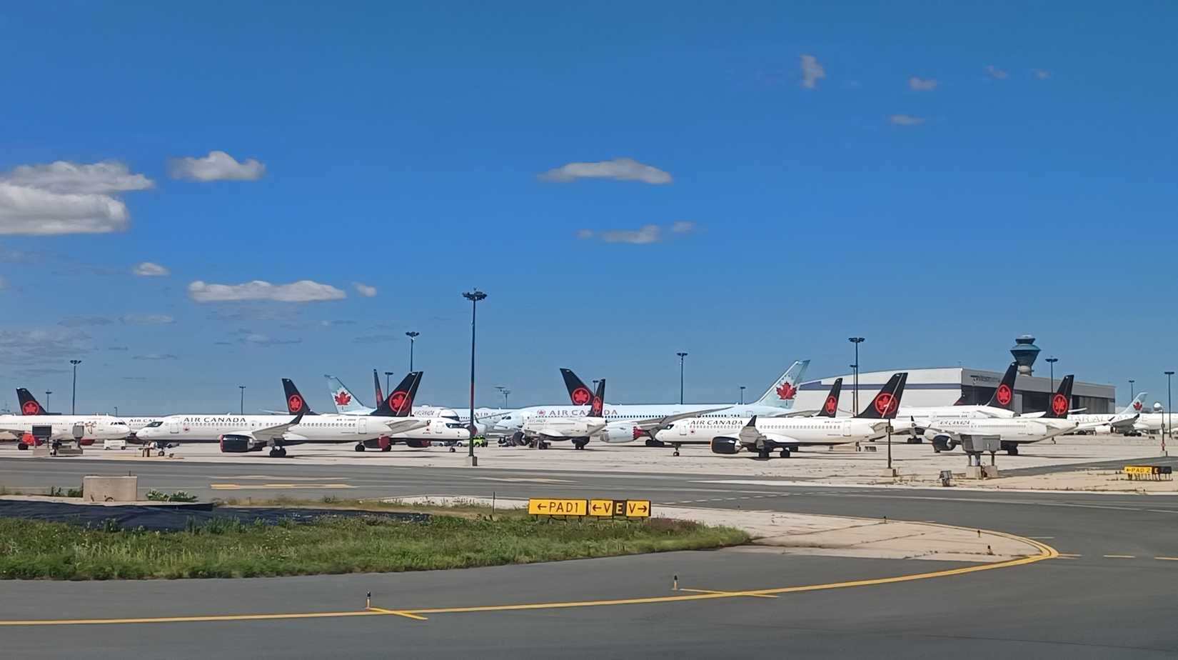 Several Air Canada airplanes stand on the tarmac at Pearson International Airport.