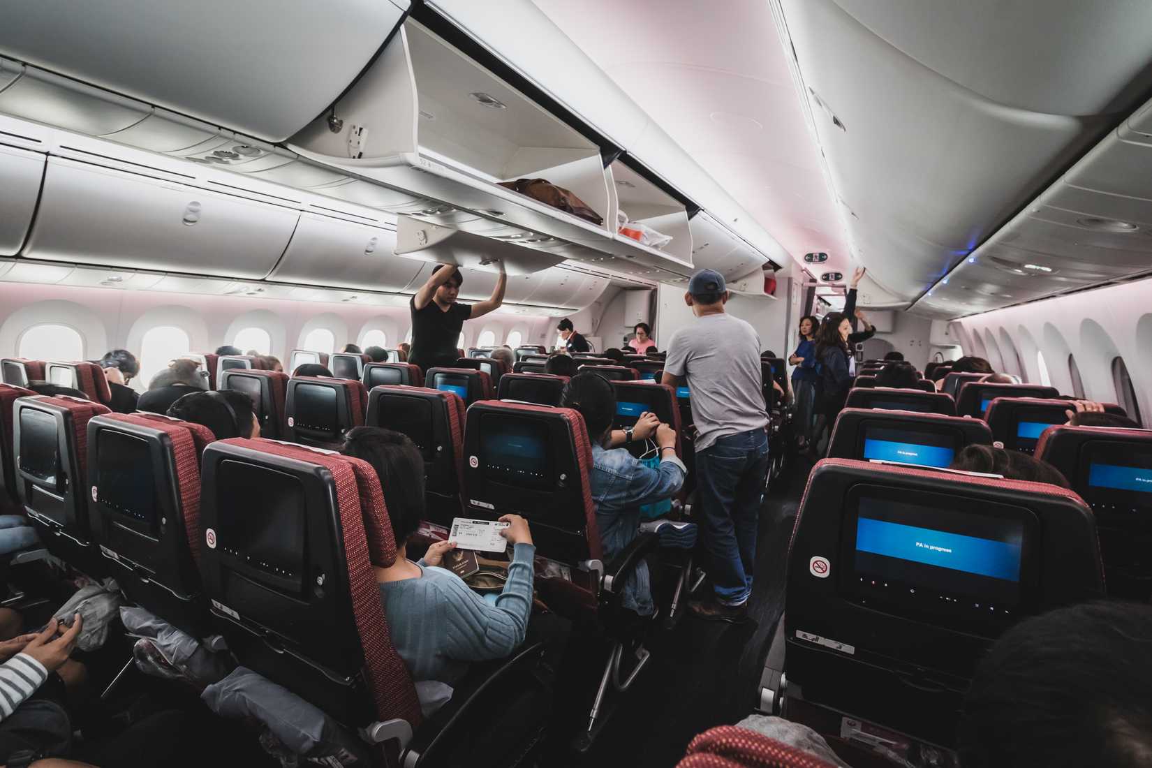 Inside the cabin of Japan Airlines Boeing 787-900. Passenger are storing their luggage and belonging before the takeoff