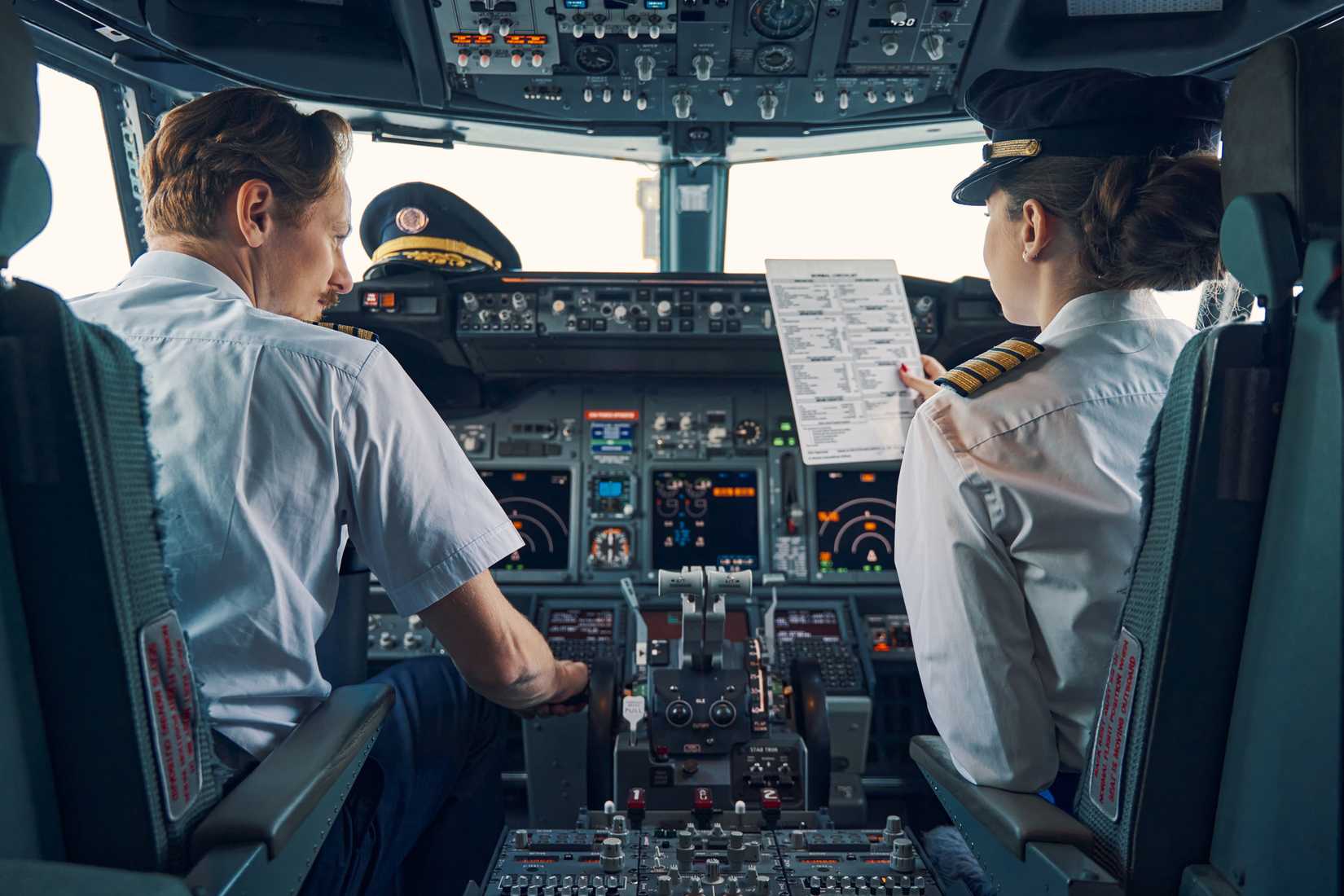 Pilot and First Officer Completing Pre Flight Check Prior To Departure