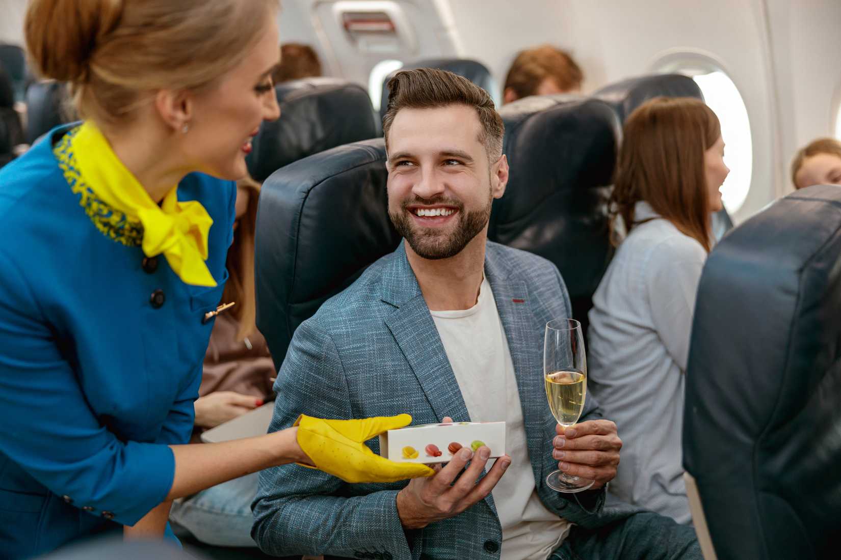 flight attendant serving passenger drinks and sweets