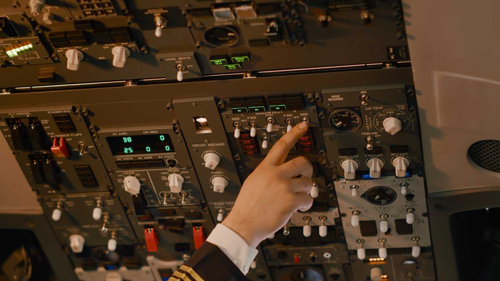 Hand pressing a control in the flight deck