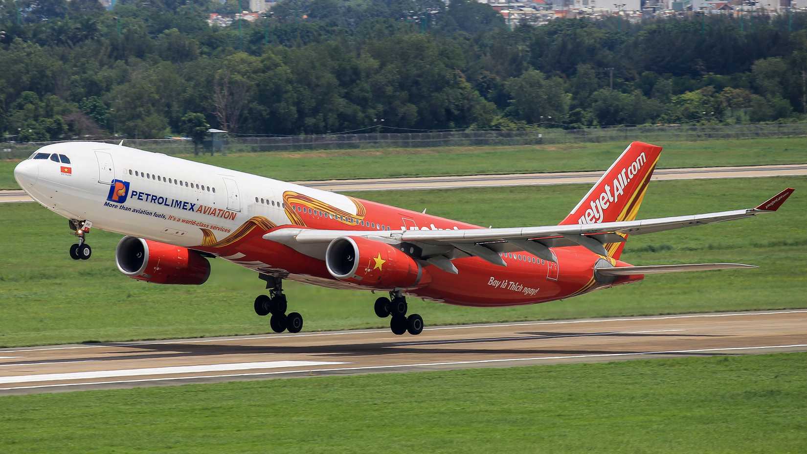 An Airbus A330-343 of Vietjet Air with registration VN-A810 in "Petrolimex Aviation" livery leave Tan Son Nhat international airport