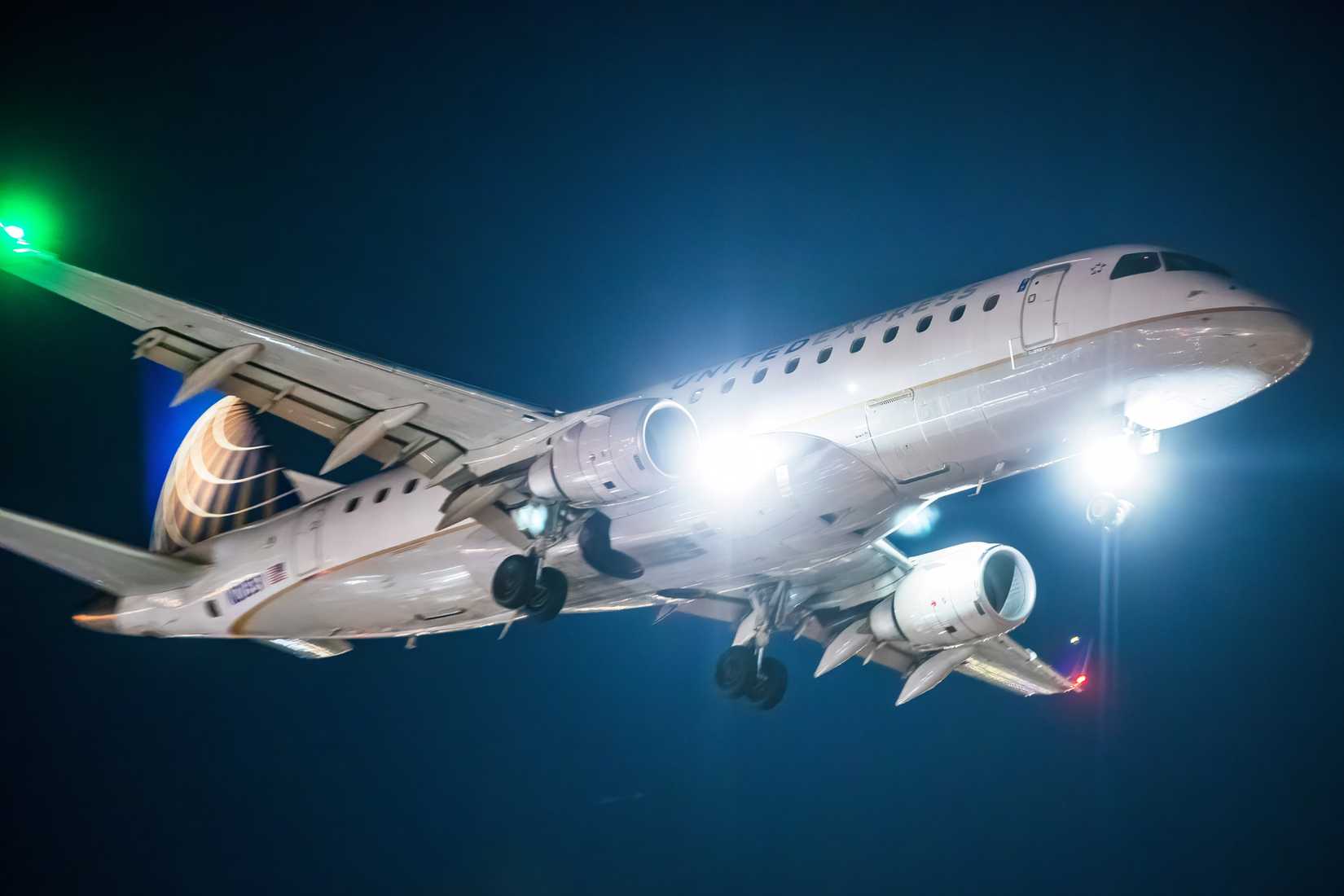 United Express Embraer E175, captured at night during landing approach.