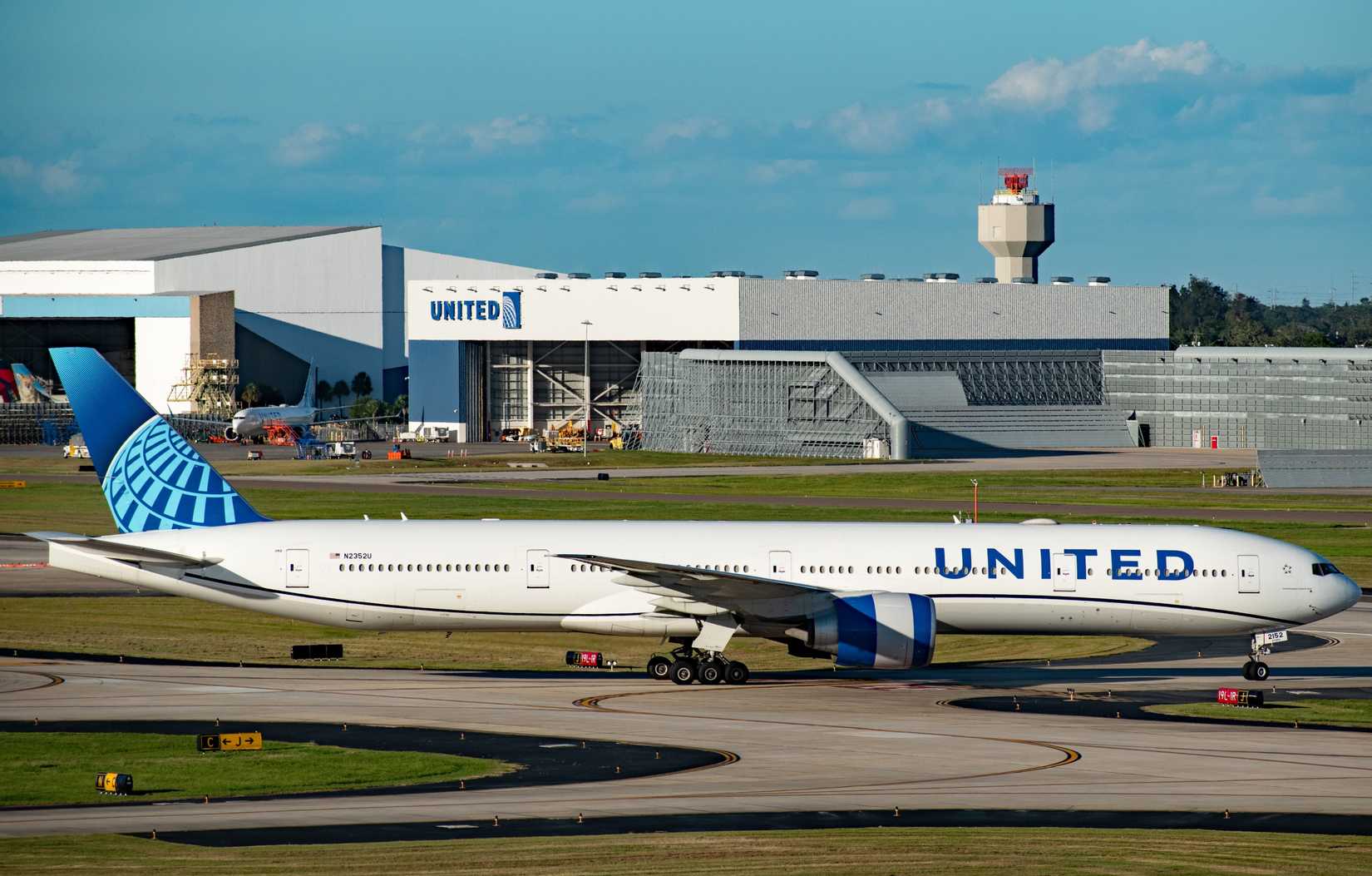 A massive United Airlines Boeing 777-300ER passenger plane, N2352U. at Tampa International Airport (TPA).