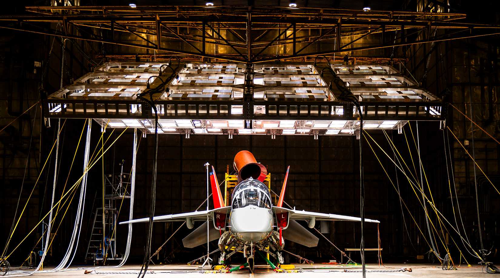 A T-7A Red Hawk sits under bright lights used to create heat in the McKinley Climatic Lab June 16 at Eglin Air Force Base, Florida.