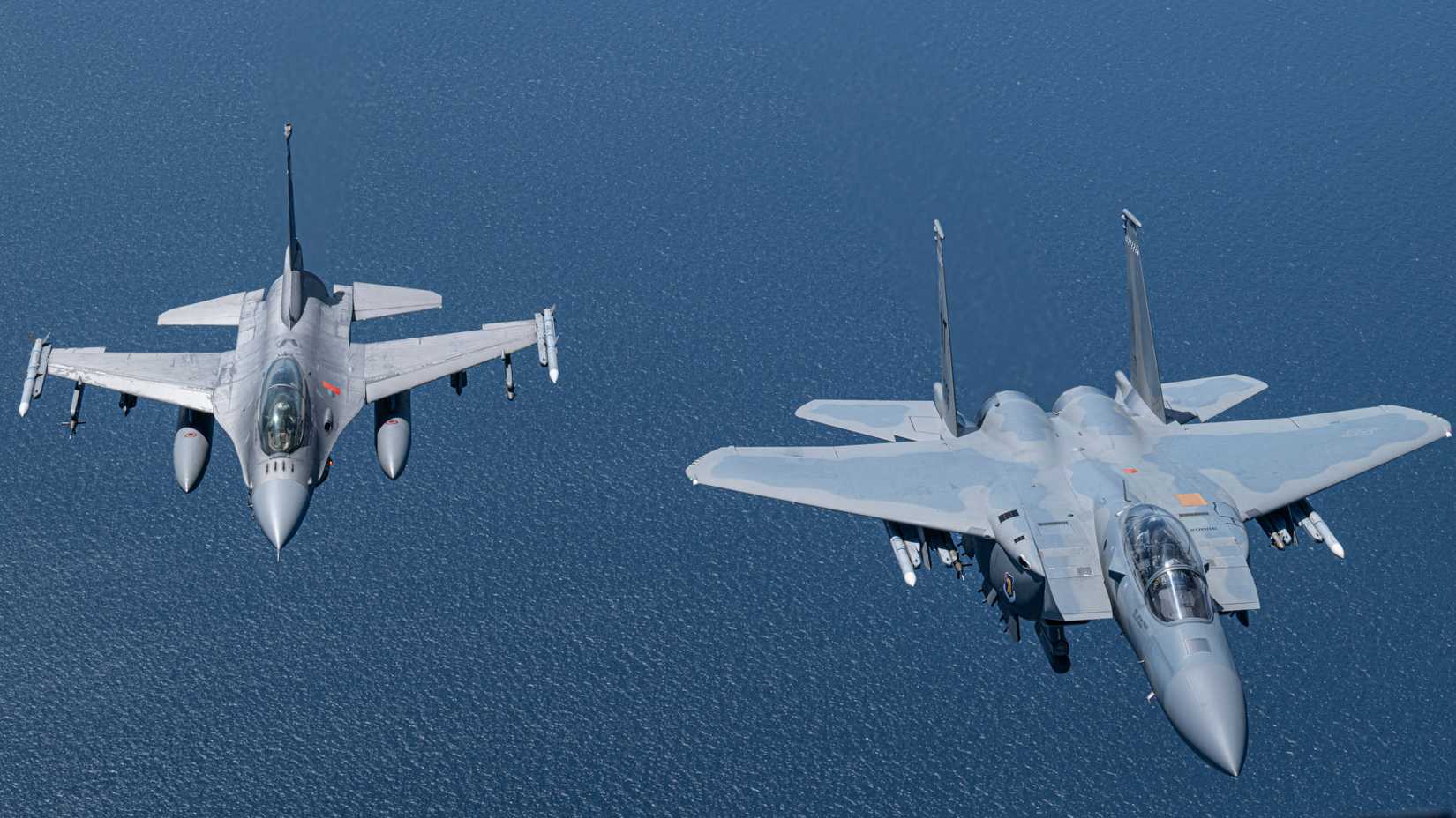 A U.S. Air Force F-15EX Eagle II and U.S. Air Force F-16D Fighting Falcon fly over the Gulf of Mexico.